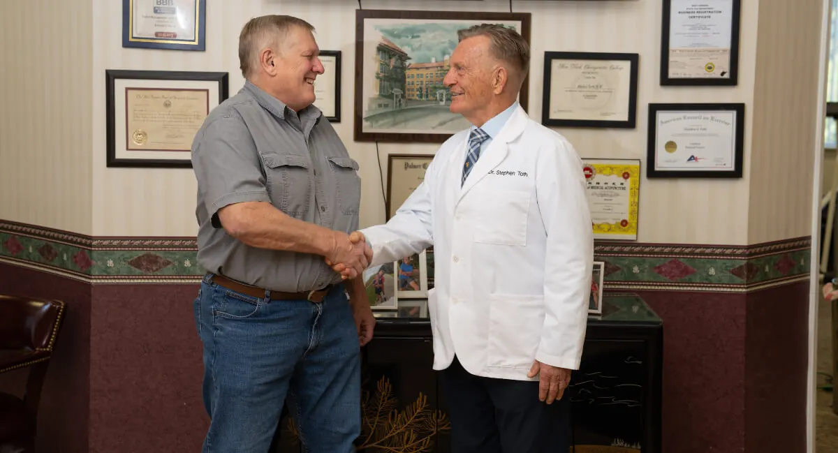 Dr. Toth shaking hands with a patient in his office